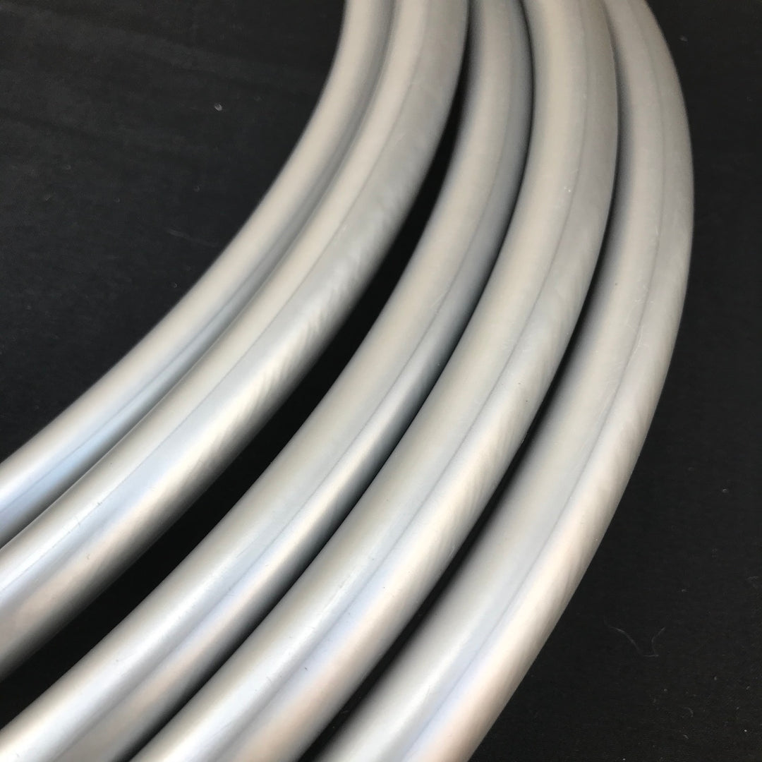 Burnished coil of silver hula hoop tubing for making hoops