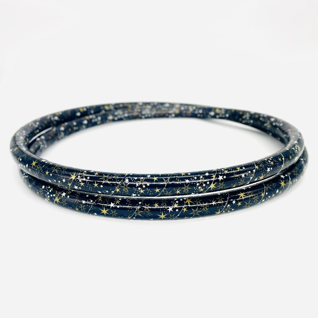 Beginner weighted hula hoop. Collapsed into two coils for travel in gold star duct tape. Black tape with gold stars
