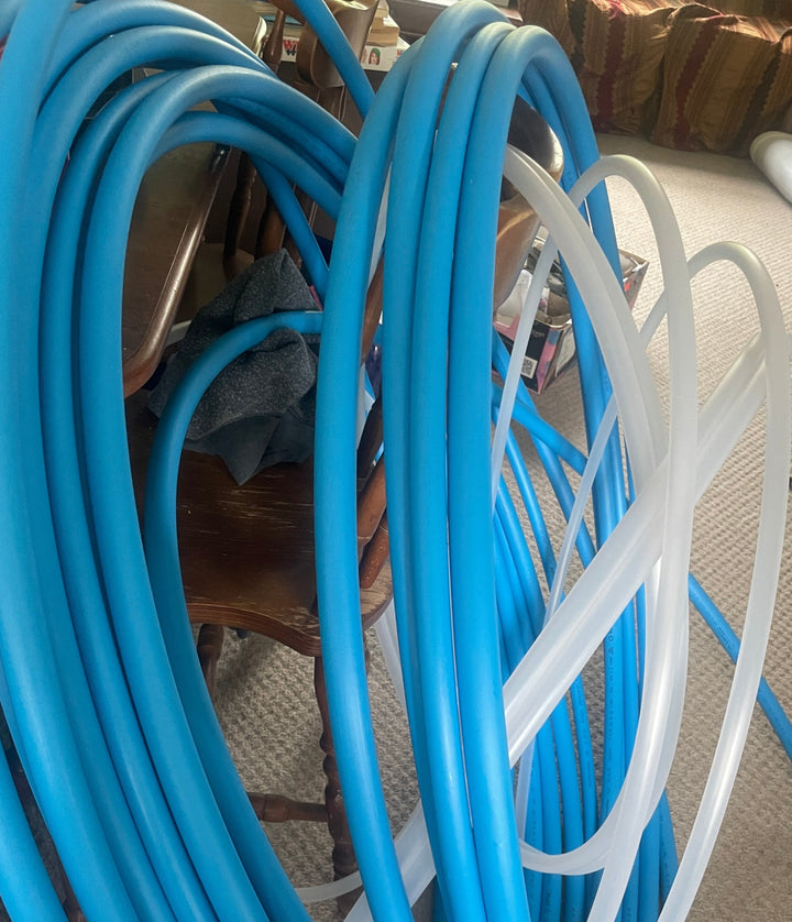 Untaped Beginner hula hoops, Blue Mdpe tubing resting against a chair